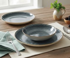 סט כלי אוכל פורצלן 18 חלקים Berlinger Haus Grey BH10302 – צלחת שטוחה וקערה אפורות מפורצלן המונחות על שולחן עץ
