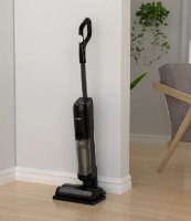 שואב אבק שוטף אלחוטי Ralph Dream Steam – המכשיר השחור עומד זקוף על רצפת עץ בהירה ליד קיר לבן
