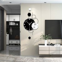 שעון קיר גדול בעיצוב ייחודי, שעון פרזול כסוף עם אלמנטים עגולים בצבע שחור לבן ואפקט שיש