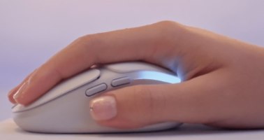 עכבר גיימינג אלחוטי Logitech G705 – יד מונחת על עכבר לבן, כפתורי צד ותאורת RGB גלויים