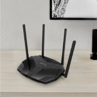ראוטר Mercusys AX1800 Dual-Band WiFi 6 MR70X – ראוטר שחור בעל ארבע אנטנות על שולחן עץ בהיר.