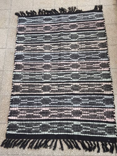 שטיח ארוג בצבע שחור עם דוגמה בצבעי פסטל