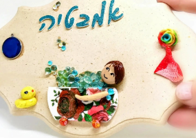 שלט עץ דקורטיבי לאמבטיה עם כיתוב מנצנץ בכחול, דמות באמבטיה מעוטרת בוורדים אדומים, בועות סבון קריסטליות וברווזון צהוב.