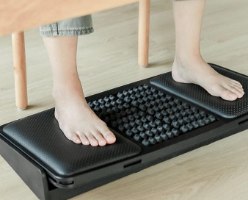 הדום ארגונומי דו צדדי ועיסוי לכפות הרגליים Comfort – כפות רגליים יחפות מונחות על הדום שחור עם משטחי עיסוי שונים
