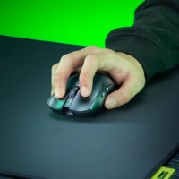 עכבר אלחוטי צבע שחור Razer Viper V4 Pro – יד אוחזת בבקר אלחוטי שחור על משטח שחור ורקע ירוק
