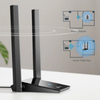 כרטיס רשת Tp-Link Archer TX20U Plus AX1800 USB – המתאם השחור עם שתי האנטנות על שולחן לצד המחשת כיסוי Wi-Fi 2 4GHz
