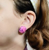 עגילי קליפס צמודים בצורת צדף (Scallop) עם טקסטורת שיש עדינה בגווני לבן, אפור ונגיעות צבע, עשויים פימו בעבודת יד.