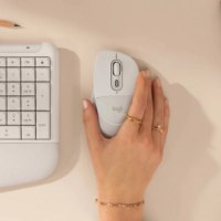 עכבר אלחוטי צבע לבן Logitech Signature Comfort Plus M850 Size L – יד אוחזת בו לצד מקלדת בהירה על שולחן