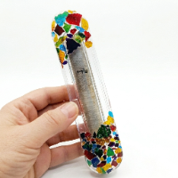 Handcrafted clear resin Mezuzah case filled with colorful crushed glass fragments at the top and bottom, showcasing an internal scroll.