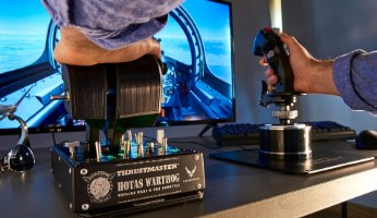 בקר טיסה ומצערת Thrustmaster HOTAS Warthog PC – ידיים מפעילות סטיק ומצערת שחורים על שולחן עבודה עם מסך מחשב