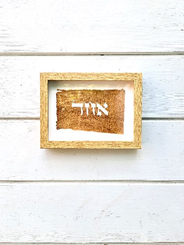 המילה "אחד " על יריעת עץ ממוסגר