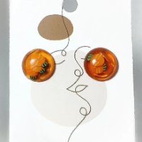 Handmade miniature carrot epoxy stud earrings, clear orange finish with tiny detailed carrots inside.