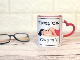 ספלים הומוריסטיים ספל קרמי עם ידית לב בצבע אדום, איור של אישה ישנה וכיתוב: אנכי במשרד וליבי בשנ"צ