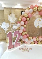 עיצוב עמדת בלונים עם פרחי ענק  ובמות עם כיתוב