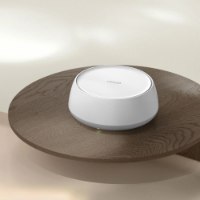 מערכת ביתית 2 יחידות בתקן Tp-Link Deco BE25 Mesh WiFi 7 – יחידה בודדת לבנה על שולחן עץ כהה מציגה נורית חיווי ירוקה חוטי