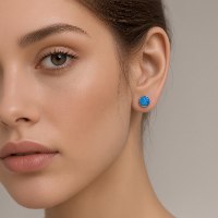 עגילי אופל כחולה מזהב צהוב 14K מונחים באלגנטיות בתוך אריזת מתנה יוקרתית של הסטודיו.