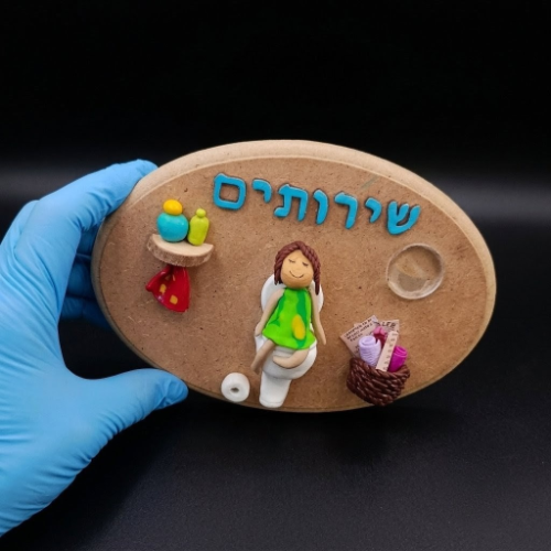 שלט עץ אובלי לשירותים דמות בשמלה ירוקה – עיצוב תלת ממדי הומוריסטי בעבודת יד מפימו