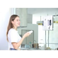 מנקה חלונות רובוטי Hobot S6 Pro – אישה מחזיקה שלט רחוק בזמן שמנקה חלונות רובוטי לבן מחובר לחלון