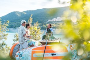 סאפ מתנפח+משוט Aqua Marina Coast PA-25C330 – שני גלשני סאפ מונחים על הדשא אנשים נחים ליד אגם