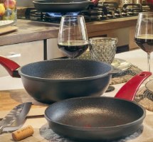 מחבת נון סטיק ביוקרמי 32 ס”מ Risoli Vinum – שתי מחבתות שחורות עם ידיות אדומות על משטח במטבח