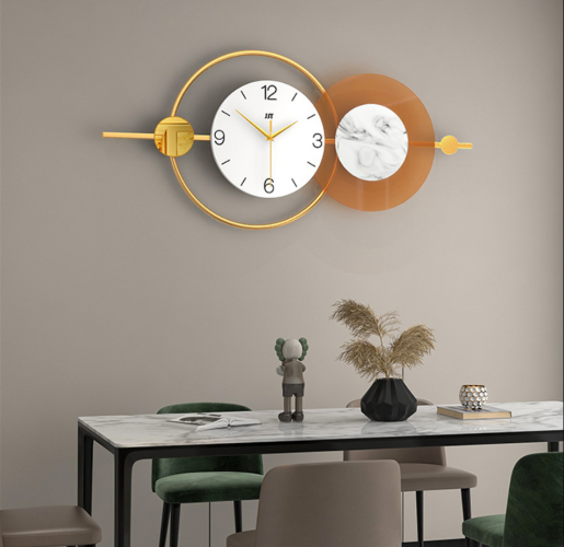 שעון קיר גדול בעיצוב מיוחד, שעון פרזול מוזהב עם אלמנט עגול כתום שקוף עם ספרות ומנגנון שקט
