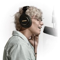 אוזניות אולפן מקצועיות Shure SRH840A – אדם עם האוזניות שר למיקרופון מול רקע לבן