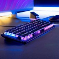 מקלדת גיימינג מכנית-אופטית Turtle Beach Vulcan II Mini – מקלדת שחורה אחת מוארת בתאורת RGB ססגונית על שולחן כהה