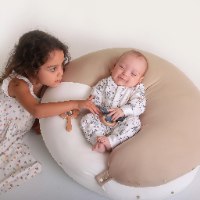 3 ב- 1: כרית הריון, כרית הנקה ופוף לתינוקות ולפעוטות. מסייעת להקלה בכאבי גב ואגן בהריון, בהנקה נסגרת ע"י פטנט ייחודי להנקה בידיים חופשיות. בתמונה: תינוק שוכב על כרית הריון והנקה מונלאב דגם נטורל של קואליטה כשהיא סגורה לצורת פוף. baby lying on pregnancy and nursing pillow Natural MoonLove  by Koalita