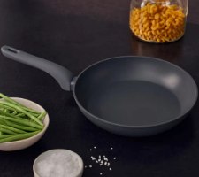 מחבת נון סטיק קרמית 26 ס”מ Resto Cas – פריט בודד מחבת אפורה כהה מונחת על משטח שחור ליד קערת שעועית ירוקה