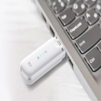 מודם סלולרי Zte MF79N USB 4G – התקן USB לבן עם לוגו ZTE ונורות כחולות במחשב נייד אלחוטית