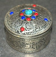 קופסה קטנה ממתכת בצבע כסף עם מכסה עשוי משובץ באבני חן, וינטאג'