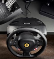 הגה מירוצים עם דוושות Thrustmaster T80 Ferrari 488 GTB Edition – הגה שחור עם לוגו פרארי במרכז ודוושות נראים על שולחן כהה