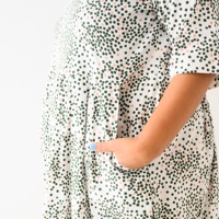 שמלה מדגם אריאל עם הדפס עיגולים בירוק בקבוק ואפרסק על רקע בצבע לבן - אחרונה במלאי במידה 17