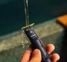 מכונת גילוח נטענת Philips One Blade QP1424 – יד אוחזת במכונה כהה עם להב ירוק כשאליה זורמים מים אלחוטי