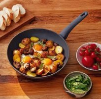 מחבת נון סטיק קרמית 28 ס”מ Resto Cas – פריט בודד המכיל ביצים תפוחי אדמה ופטריות מונח על שולחן עץ