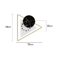שעון קיר גדול בעיצוב ייחודי, שעון פרזול בצורת משולש מוזהב, ואלמנטים בצבע שחור שיש ולבן שיש