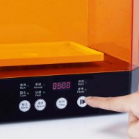 מכונת שטיפה וייבוש Creality UW-03 – פאנל הבקרה השחור של המכונה עם תצוגת זמן דיגיטלית ויד לוחצת על כפתור ההפעלה