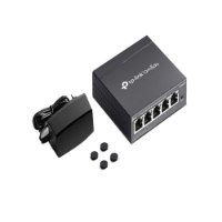 מתג לא מנוהל Omada DS105G-M2 – המתג ספק הכוח וארבע רגליות גומי מונחים על רקע לבן