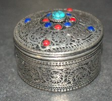 קופסה קטנה ממתכת בצבע כסף עם מכסה עשוי משובץ באבני חן, וינטאג'