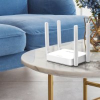 ראוטר Mercusys AC1200 Wireless Dual Band AC10 – מונח על שולחן קפה משיש ליד ספה כחולה