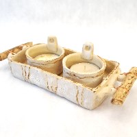 פמוטי קרמיקה על מגש בשילוב ענפי עץ טבעיים