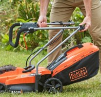מכסחת דשא נטענת Black+Decker BCMW3318N – אדם מחזיק את ידית המכסחת על הדשא