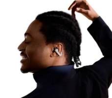 אוזניות אוזן-פתוחה אלחוטיות Shokz OpenDots One – גבר חייכן מציג אוזנייה בודדת בצבע בהיר באוזנו השמאלית על רקע לבן