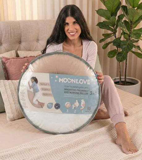 אישה בהריון מחזיקה אריזה עם כרית הריון והנקה MoonLove
