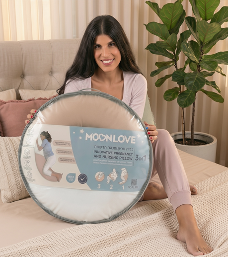 אישה בהריון מחזיקה אריזה עם כרית הריון והנקה MoonLove