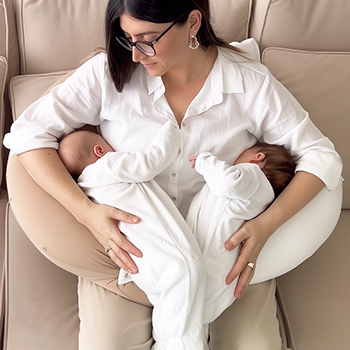 Tandem nursing twins in the criss-cross hold using the Koalita MoonLove twin nursing pillow.