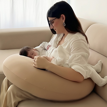 Tandem nursing twins in the football hold using the Koalita MoonLove twin nursing pillow.